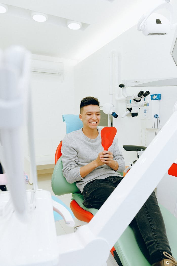 Happy young patient in dental clinic awaiting treatment with modern equipment