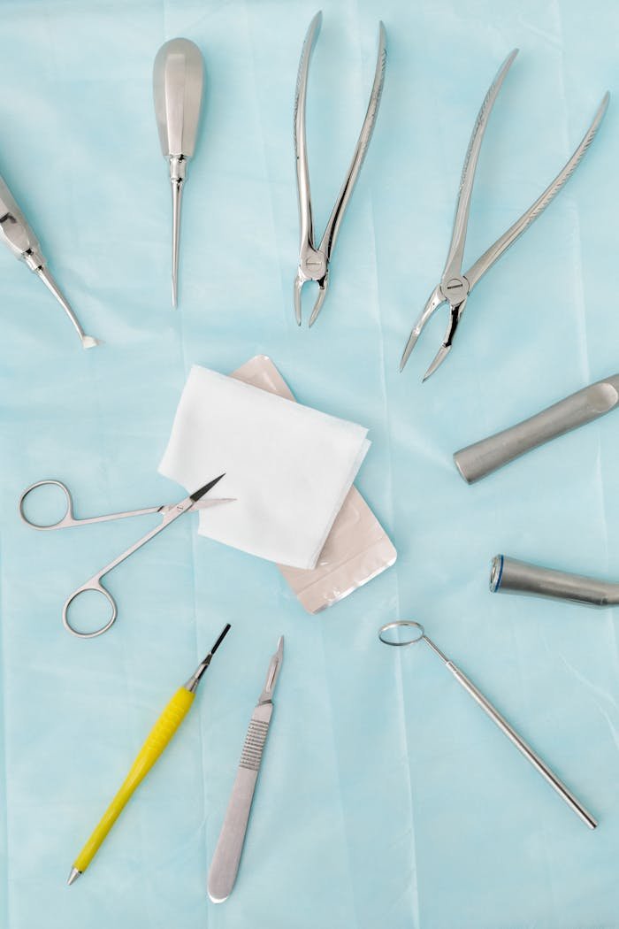 Top view of assorted dental surgical instruments on a blue background, sterile and ready for use.